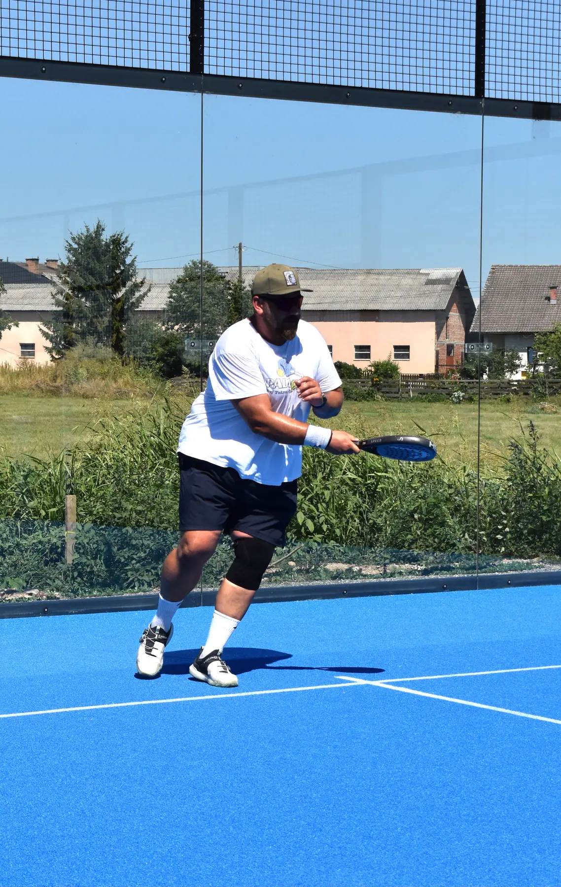 Igralec udarja forehand na modrem igrišču